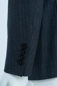 Quatre boutons disposés à plat sur une manche de veste